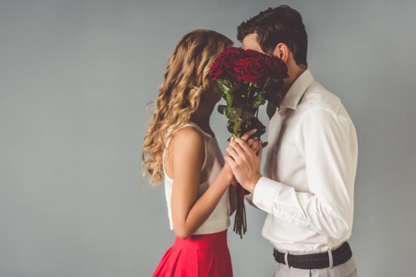 man giving roses to woman